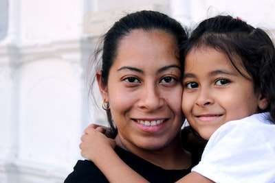 A happy young girl giving her mum a hug