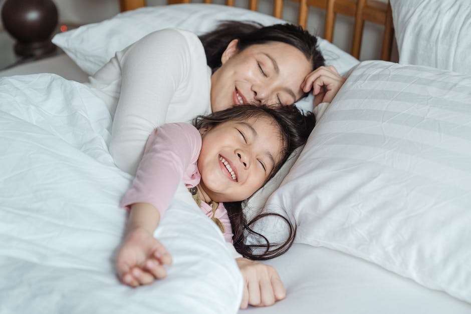 A Mum and young daughter having a cuddle in bed